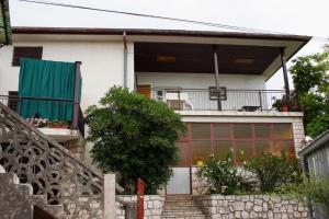 a white house with a balcony and a staircase at Double Room Novi Vinodolski 2350a in Novi Vinodolski