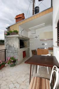 a patio with a table and a stone fireplace at Double Room Novi Vinodolski 2350a in Novi Vinodolski