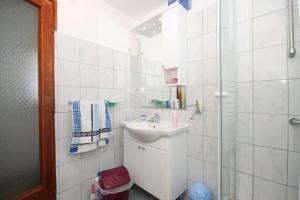 y baño blanco con lavabo y ducha. en Studio Brsec 2359a, en Brseč