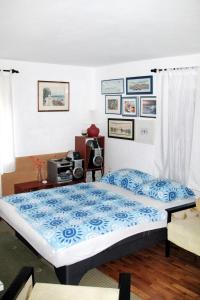 ein Schlafzimmer mit einem Bett mit einer blauen Bettdecke in der Unterkunft Apartments with WiFi Novi Vinodolski - 2382 in Novi Vinodolski