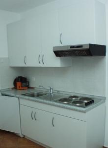 a white kitchen with a sink and a stove at Apartment Rabac 2323a in Rabac