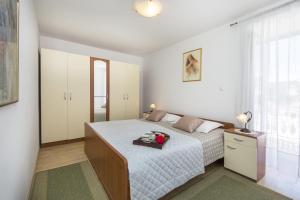 a small bedroom with a bed and a window at Apartments by the sea Duga Luka - Prtlog, Labin - 2358 in Drenje