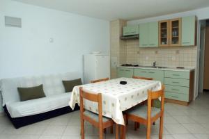 a kitchen with a table and a couch in a room at Apartments by the sea Duga Luka - Prtlog, Labin - 2367 in Drenje