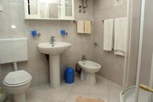 a bathroom with a toilet and a sink at Apartments by the sea Duga Luka - Prtlog, Labin - 2367 in Drenje