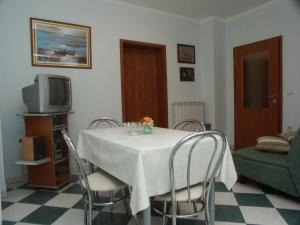 een eetkamer met een tafel met stoelen en een tv bij Apartments with a parking space Presika, Labin - 2370 in Labin