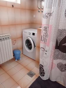 a bathroom with a washing machine and a shower curtain at Apartment Rabac 2340a in Rabac