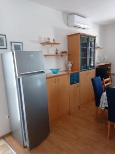 a kitchen with a refrigerator and wooden cabinets at Apartment Rabac 2340a in Rabac