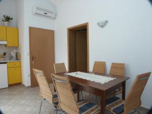 a dining room with a wooden table and chairs at Apartment Crikvenica 2354e in Crikvenica