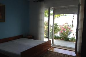 um quarto com uma cama e uma porta de vidro deslizante em Apartments by the sea Sveti Juraj, Senj - 2399 em Sveti Juraj