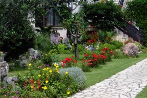 a garden of flowers in front of a house at Apartments with a parking space Smrika, Kraljevica - 2365 in Šmrika