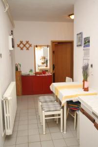 eine Küche mit einem Tisch und Stühlen sowie ein Zimmer in der Unterkunft Apartments with a parking space Smrika, Kraljevica - 2365 in Šmrika