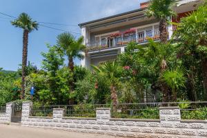 budynek z palmami przed nim w obiekcie Apartments with a parking space Lovran, Opatija - 2342 w mieście Lovran