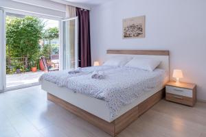 sypialnia z łóżkiem i dużym oknem w obiekcie Apartments with a parking space Lovran, Opatija - 2342 w mieście Lovran