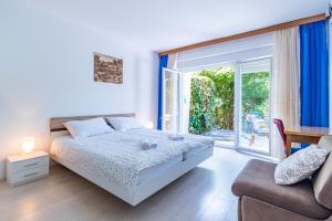 sypialnia z łóżkiem, kanapą i oknem w obiekcie Apartments with a parking space Lovran, Opatija - 2342 w mieście Lovran