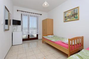 a bedroom with a bed and a tv in a room at Twin Room Selce 2362a in Selce