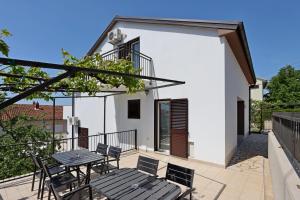 eine Terrasse mit Tisch und Stühlen auf einem Balkon in der Unterkunft Triple Room Selce 2362c in Selce