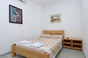ein kleines Schlafzimmer mit einem Bett und einem Nachttisch in der Unterkunft Triple Room Selce 2362c in Selce