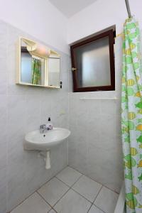a white bathroom with a sink and a mirror at Triple Room Selce 2362c in Selce