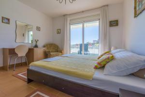 a bedroom with a large bed with a large window at Apartments by the sea Selce, Crikvenica - 2356 in Selce