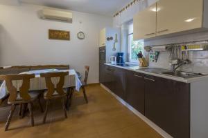 a kitchen with a sink and a table with chairs at Apartments by the sea Selce, Crikvenica - 2356 in Selce