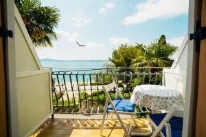 a balcony with a table and chairs and a view of the ocean at Studio Selce 2364c in Selce