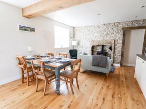 a dining room with a table and chairs and a fireplace at Woodgate in Buxton