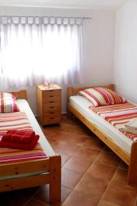 a bedroom with two beds and a dresser and a window at Apartments with a parking space Valbandon, Fazana - 2310 in Fondole