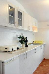 a white kitchen with white cabinets and a sink at Apartments with a parking space Valbandon, Fazana - 2310 in Fondole