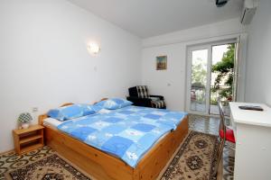 a bedroom with a bed with a blue comforter at Apartments and rooms with parking space Selce, Crikvenica - 2379 in Selce