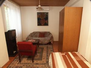 a small bedroom with a bed and a red chair at Apartment Selce 2372c in Selce