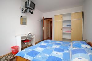 a bedroom with a blue bed and a desk at Triple Room Selce 2379b in Selce
