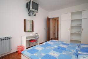 a bedroom with a bed and a tv on the wall at Triple Room Selce 2379a in Selce
