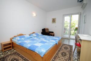 a bedroom with a bed with a blue comforter at Triple Room Selce 2379d in Selce