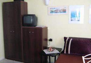 a living room with a tv and a wooden cabinet at Studio Novi Vinodolski 2382a in Novi Vinodolski