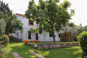 Biały dom z drzewem w ogrodzie w obiekcie Apartments with a parking space Njivice, Krk - 2391 w mieście Nijvice