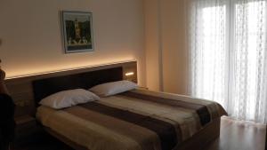 a bedroom with a bed with two pillows and a window at Apartments by the sea Selce, Crikvenica - 2392 in Selce