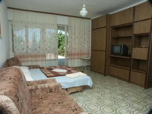 a bedroom with a bed and a couch and a tv at Apartments and rooms with parking space Dramalj, Crikvenica - 2386 in Dramalj