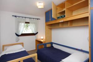 a small bedroom with two beds and a window at Apartments with a parking space Njivice, Krk - 2391 in Njivice