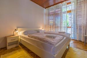 a bedroom with a bed and a large window at Apartments with a parking space Selce, Crikvenica - 2381 in Selce