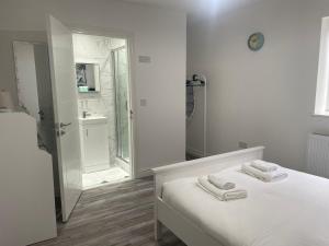 a white bedroom with a bed and a bathroom at CityBreaks Rooms with Free Parking in Liverpool