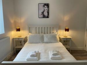 a bedroom with a white bed with two towels on it at CityBreaks Rooms with Free Parking in Liverpool