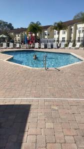 una persona está nadando en una piscina en Orlando House Disney Area, en Kissimmee