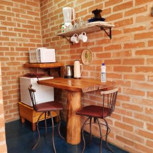 une cuisine avec une table en bois et deux chaises dans l'établissement Chalé Caminho da Montanha, à Gonçalves