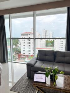 ein Wohnzimmer mit einem Sofa und einem großen Fenster in der Unterkunft Hotel Sexta Avenida Inn in Montería