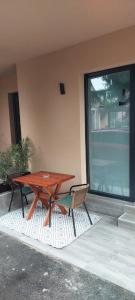 uma mesa de madeira e duas cadeiras ao lado de um edifício em Apartman Bajka em Ruma