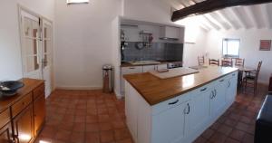 a kitchen with white cabinets and a wooden counter top at 3 bedroom apartment overlooking river in Agde