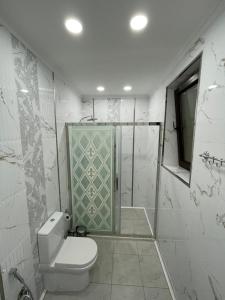 a bathroom with a toilet and a glass shower at Villa Qusar in Qusar +30 photos