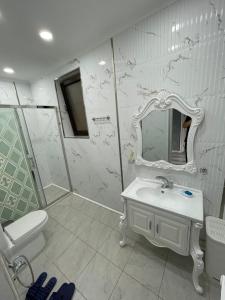 a white bathroom with a sink and a mirror at Villa Qusar in Qusar
