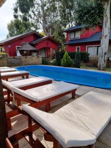 - un groupe de tables de pique-nique à côté d'une piscine dans l'établissement Complejo Cabañas del Jaguel, à Santa Teresita