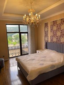 a bedroom with a large bed and a chandelier at Villa Qusar in Qusar
